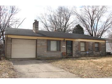 Charming single-story home with stone exterior, attached garage and driveway at 7625 E 35Th St, Indianapolis, IN 46226