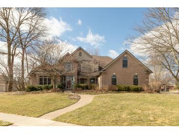 Charming brick home featuring a manicured lawn and winding brick walkway leading to the front entrance at 7806 Ashtree Dr, Indianapolis, IN 46259