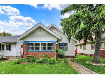 Charming home featuring brick accents, blue trim, and lush landscaping, creating a welcoming curb appeal at 960 Cameron St, Indianapolis, IN 46203