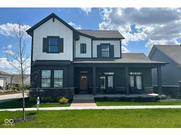 Charming two-story home featuring a welcoming front porch and modern black and white color scheme at 1225 Amberley Way, Westfield, IN 46074