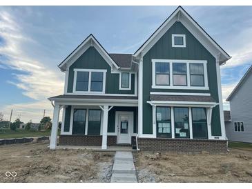 Beautiful craftsman-style home featuring green siding, brick accents, and white trim at 13610 Grand Abbey Way, Fishers, IN 46037