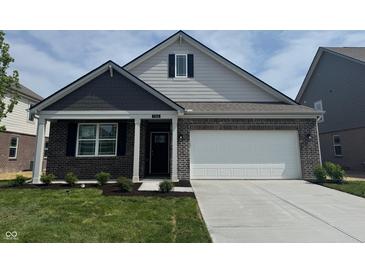 Charming one-story home features brick accents, a two-car garage, and a well-manicured front lawn at 1366 Foxtail Ln, Greenwood, IN 46143