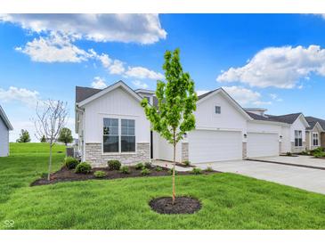 Charming home featuring a two-car garage and inviting curb appeal with stone accents and a well-manicured lawn at 1627 Clover Crossing Dr, Greenfield, IN 46140