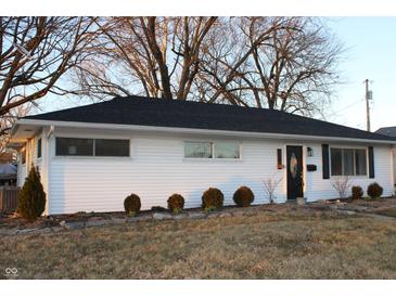 Charming single-story home featuring white siding, a black roof, and manicured landscaping at 516 Northfield Dr, Lebanon, IN 46052