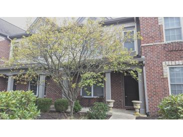 Charming brick townhome with inviting front porch and mature landscaping at 6691 Beekman Pl, Zionsville, IN 46077