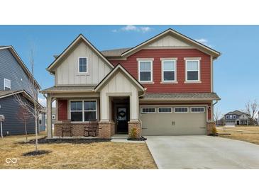 Inviting two-story home featuring red siding, a covered porch with rocking chairs, and an attached two-car garage at 1945 Clement St, Westfield, IN 46074