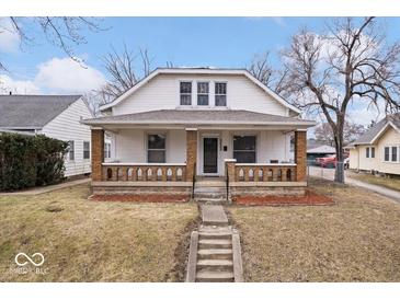 Charming two-story home featuring a covered front porch with brick pillars, offering a cozy curb appeal at 2532 Madison Ave, Indianapolis, IN 46225