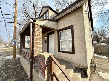 Charming home featuring brick accents, stairs leading to the front door, and a cozy covered porch at 2821 E 13Th St, Indianapolis, IN 46201