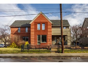 Charming two-story red brick home with a well-manicured front yard and inviting curb appeal at 304 E 17Th St, Indianapolis, IN 46202