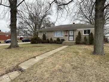 Charming stone home with mature trees and walkway to the front entrance at 3851 N Campbell Ave, Indianapolis, IN 46226