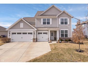 Charming two-story home with a three-car garage and well-manicured lawn in a suburban neighborhood at 5646 Mahogany Dr, Noblesville, IN 46062