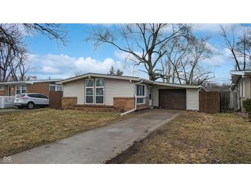 Charming ranch-style home with brick accents and an attached carport on a sunny day at 1611 Elmhurst Dr, Indianapolis, IN 46219