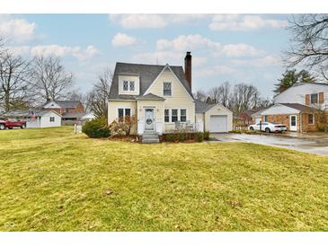 Charming yellow two-story home with an attached garage and a large front yard at 19 Orchard Ln, Anderson, IN 46011