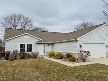 Charming single-story home with neutral siding, attached garage, and manicured landscaping at 3408 Village Dr, Anderson, IN 46011