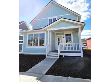 Charming light blue two-story home with a welcoming front porch and large windows at 5421 Upper Garden Way, Zionsville, IN 46077