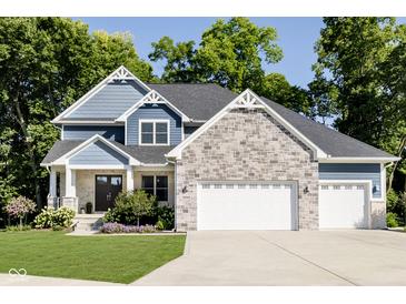 Beautiful two-story home with a stone and blue shingle exterior and a well-manicured front lawn at 6208 W Foster Ridge Ln, Pendleton, IN 46064