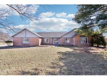 Charming single story brick home, featuring a well-manicured lawn and symmetrical architecture at 10709 E County Road 100 N, Indianapolis, IN 46234