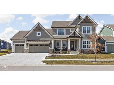 Charming two-story home with a three-car garage, covered porch, and beautiful architectural details at 15675 Woodford Dr, Westfield, IN 46074