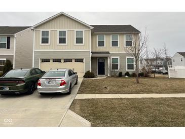 Charming two-story home featuring an attached garage and well-maintained front yard and two parked cars at 215 Traditions Pass, Greenwood, IN 46143