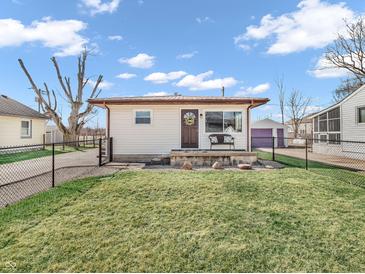Charming single-story home with a well-manicured lawn, featuring a cozy front porch and complementary yard decor at 4592 Gordon Dr, Plainfield, IN 46168