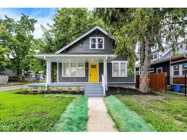 Charming renovated home with a bright yellow door and inviting front porch at 1304 N Tuxedo St, Indianapolis, IN 46201