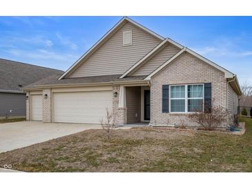 Charming single Gathering home features a three car garage, brick accents, and neutral siding, and a well-manicured lawn at 3328 Stoddard Pl, Indianapolis, IN 46217