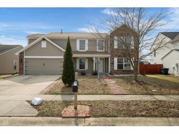 Inviting two-story home featuring a blend of vinyl siding, brick accents, attached garage, and well-maintained front yard at 6677 W Longview Dr, McCordsville, IN 46055