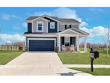 Two-story home boasts a front-facing two-car garage and a cozy front porch with rocking chairs at 6919 Sable Point Dr, Brownsburg, IN 46112