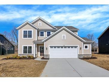 Charming two-story home featuring a two-car garage, stone accents, and a well-manicured lawn at 7168 Jackson Dr, Cumberland, IN 46229