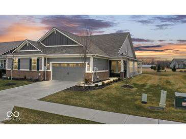 Charming home with a two-car garage and well-maintained lawn at 11758 Harvester S Cir, Noblesville, IN 46060