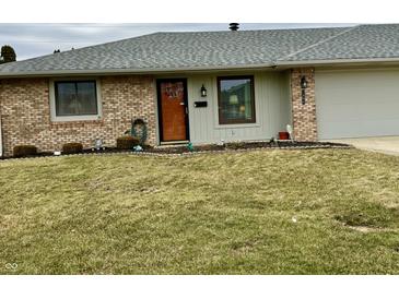 Charming brick home with a welcoming front yard, cozy front door and attached garage at 1408 Lawrence Way, Anderson, IN 46013