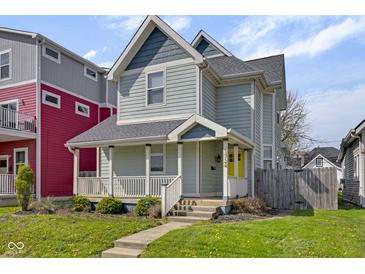 Charming two-story home featuring a welcoming front porch and a bright yellow front door at 1724 Prospect St, Indianapolis, IN 46203