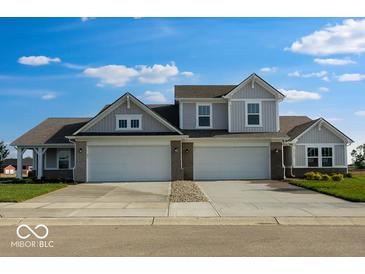 Charming home featuring a three car garage, gray siding, and a well manicured lawn at 2150 Aviary Ln, Danville, IN 46122