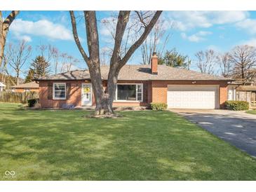 Charming brick home with a well-manicured lawn and mature trees in a peaceful neighborhood at 4905 N Dearborn St, Indianapolis, IN 46205