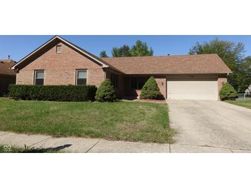 Charming brick home featuring a well-manicured lawn and attached two-car garage at 540 Louise Dr, Indianapolis, IN 46217