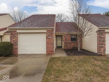 Charming single-story home with a red brick facade and attached single car garage at 5457 Happy Hollow, Indianapolis, IN 46268