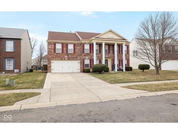 Beautiful brick two-story home with attached garage, landscaped front yard and ample driveway at 5630 N Rockingham Ln, McCordsville, IN 46055