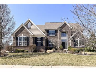 Beautiful brick home with manicured lawn, large windows, black shutters, and well-kept landscaping at 14034 Wicklow Ln, Fishers, IN 46040