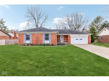 Charming single story brick home with a well-manicured lawn and an attached two car garage at 3125 Anniston Dr, Indianapolis, IN 46227