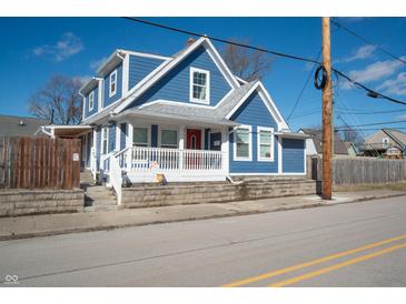 Charming blue two-story home with a covered front porch and well-maintained landscaping at 3406 E 20Th St, Indianapolis, IN 46218