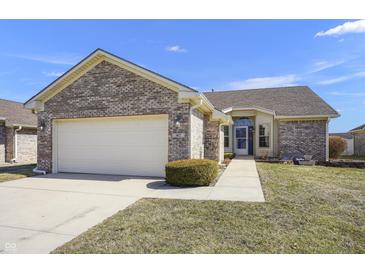 Charming brick home featuring an attached two-car garage, manicured lawn, and inviting entryway at 3677 Cedar Cove Ct, New Palestine, IN 46163