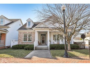 Charming brick and siding home featuring a covered porch and landscaped front yard at 4215 Heyward Pl, Indianapolis, IN 46250