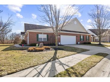 Charming brick home featuring a two-car garage and manicured front yard with green shutters and a welcoming appeal at 5115 Baltustrol Dr, Avon, IN 46123
