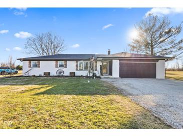 Charming ranch style home with a 2-car garage, and beautifully decorated front lawn at 5195 N Frontage Rd, Fairland, IN 46126