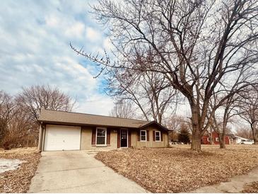 Charming single-story home featuring a garage and a well-maintained front yard with mature trees at 6116 Wixshire Dr, Indianapolis, IN 46254