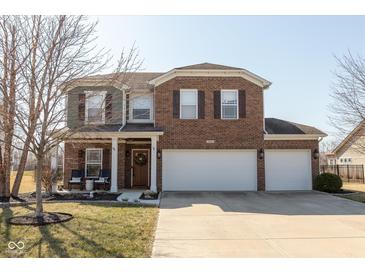 Charming two-story home featuring brick and siding, a welcoming front porch, and a spacious three-car garage at 7675 Winding Lake S Dr, Noblesville, IN 46062
