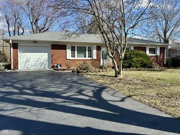 Red brick ranch-style home with attached garage and long asphalt driveway at 1031 Schleicher Ave, Indianapolis, IN 46229