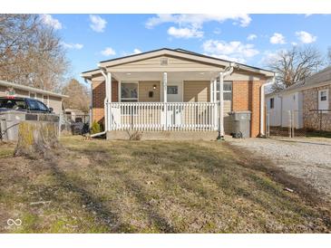 Charming home featuring a cozy front porch with white railings and a combination of brick and siding exterior at 1131 Madeira St, Indianapolis, IN 46203