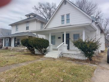 Charming two-story white home featuring a inviting front porch at 1311 N Olney St, Indianapolis, IN 46201