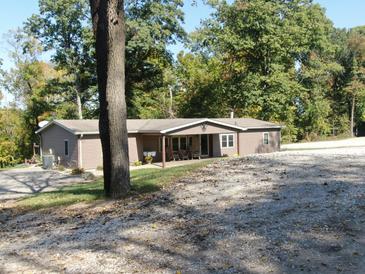 Charming single-story home featuring a cozy covered front porch and set amidst a lush, treed landscape at 2387 Bill Smith Rd, Martinsville, IN 46151